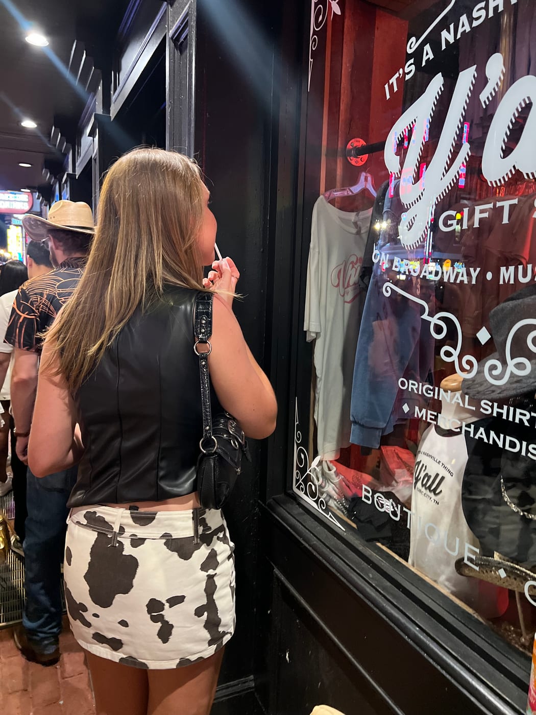 A Broadway Betties checking her outfit and applying lipstick at a mirror